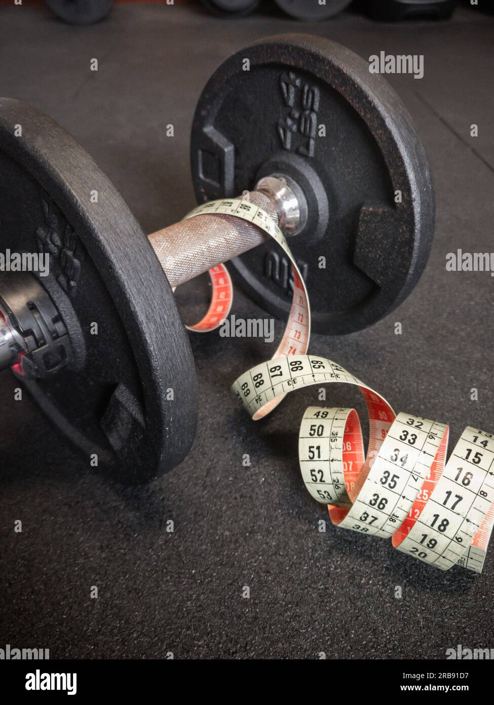 Primo piano di manubri e metro neri arrugginiti da 4,4 kg o 2 kg sul pavimento della palestra. Fitness, allenamento con pesi o stile di vita sano Foto Stock