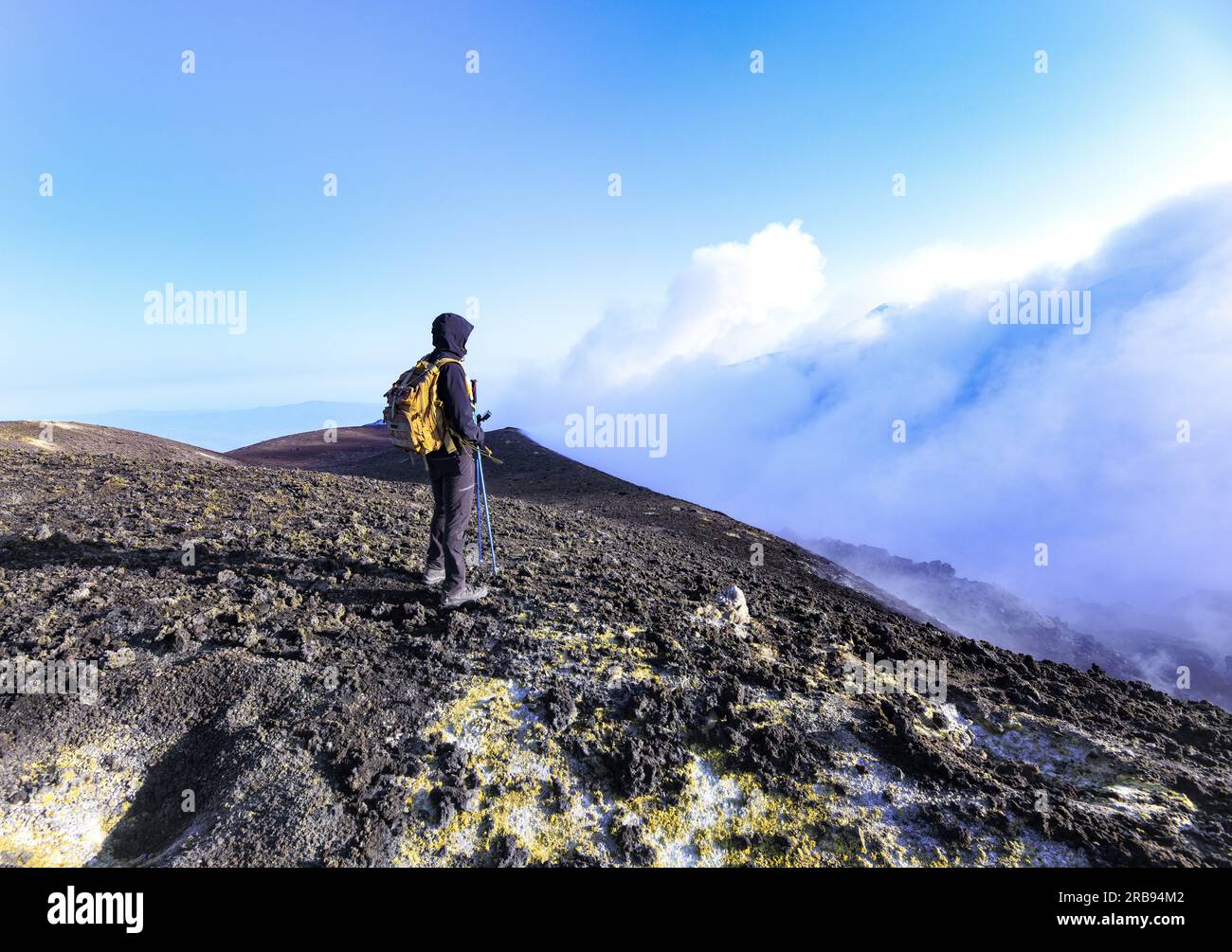 Turista sul cratere di cima dell'Etna durante giornata di sole con cielo blu - escursioni e tour turistici in Sicilia Foto Stock