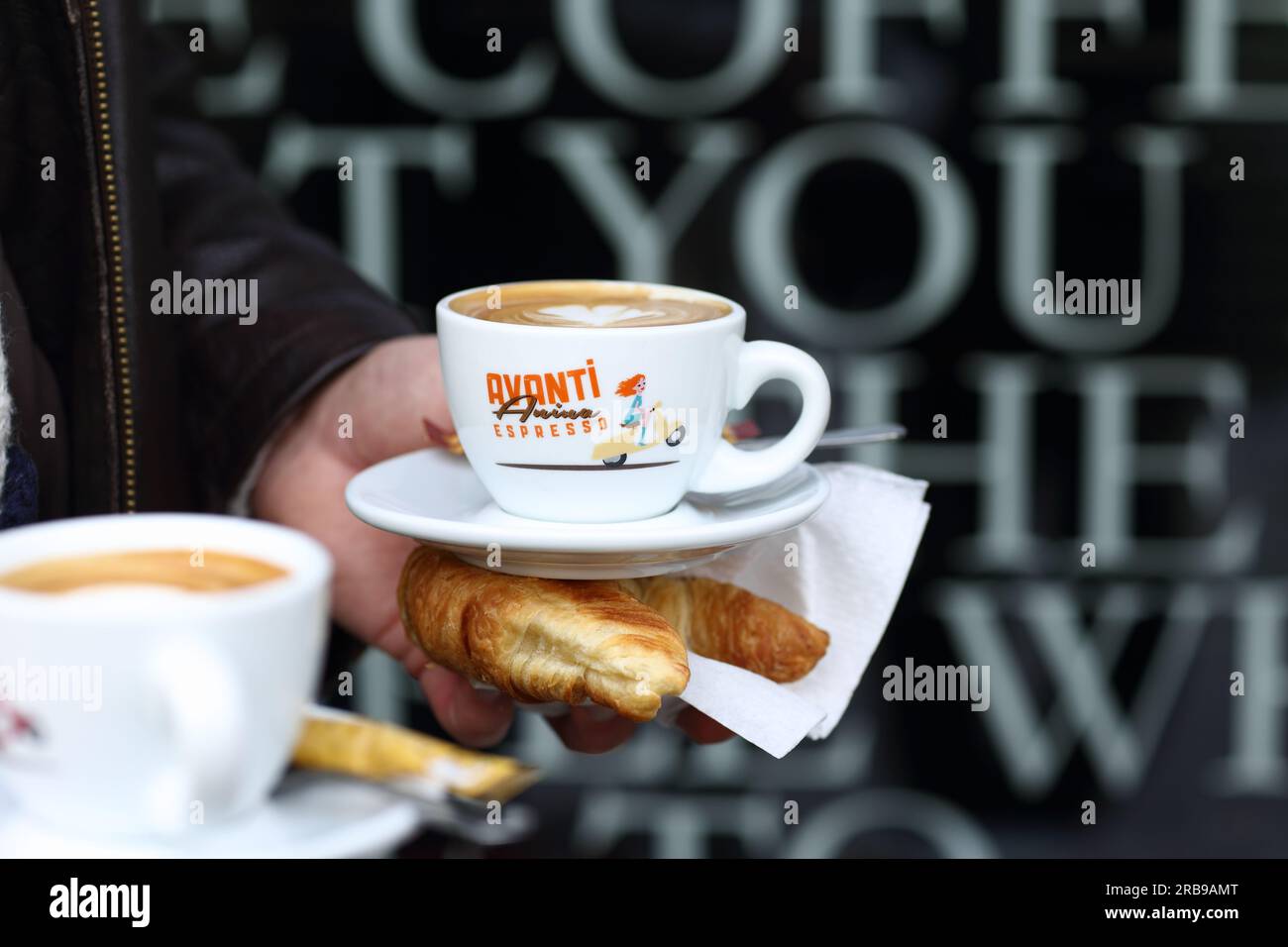 Tazza di caffè e croissant a mano Frankfurt am Main, Germania Foto Stock