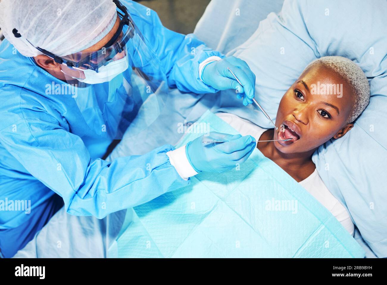 Dentista, donna e strumenti in bocca in clinica per cavità, sbiancamento dei denti e aiuto mano per il dolore. Dentista, paziente e vista dall'alto per il dente Foto Stock