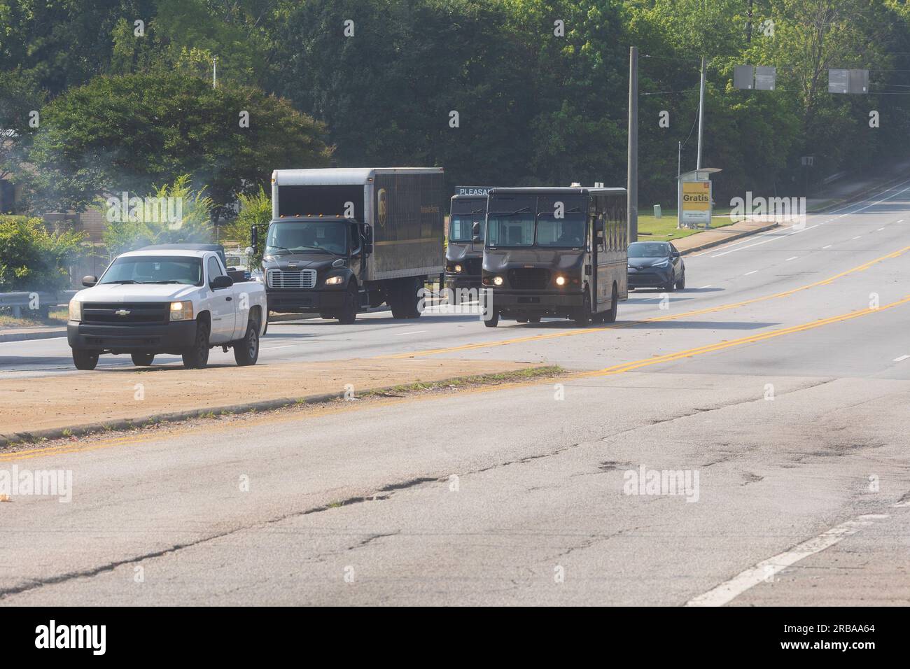 Atlanta, Georgia / USA – 29 giugno 2023: Tre camion UPS viaggiano lungo una strada il 29 giugno 2023 ad Atlanta, Georgia. Foto Stock