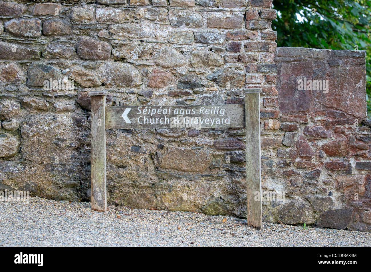 Cartello di legno per Church and Graveyard, scritto anche in irlandese Foto Stock