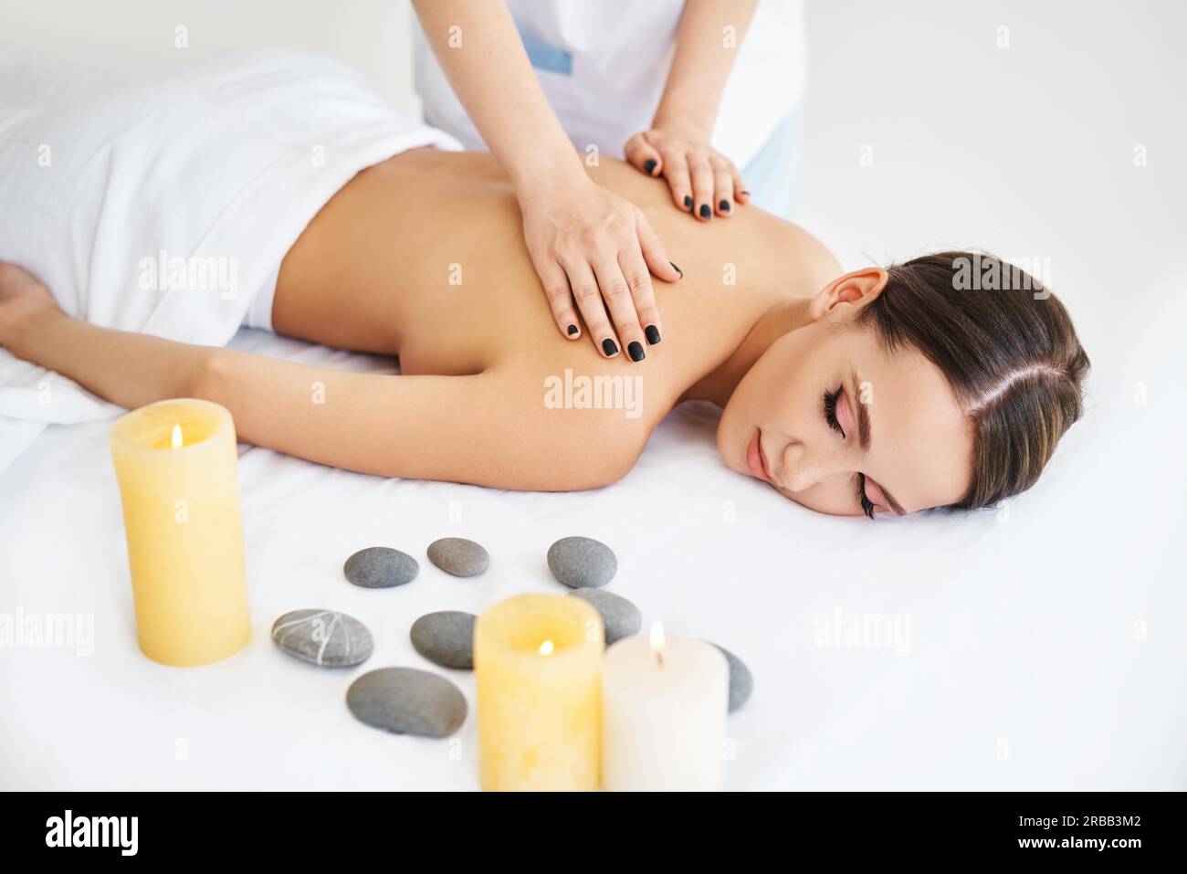 Una giovane donna che ama rilassarsi con un massaggio alla schiena presso il centro benessere. Cura del corpo, concetto di riposo Foto Stock