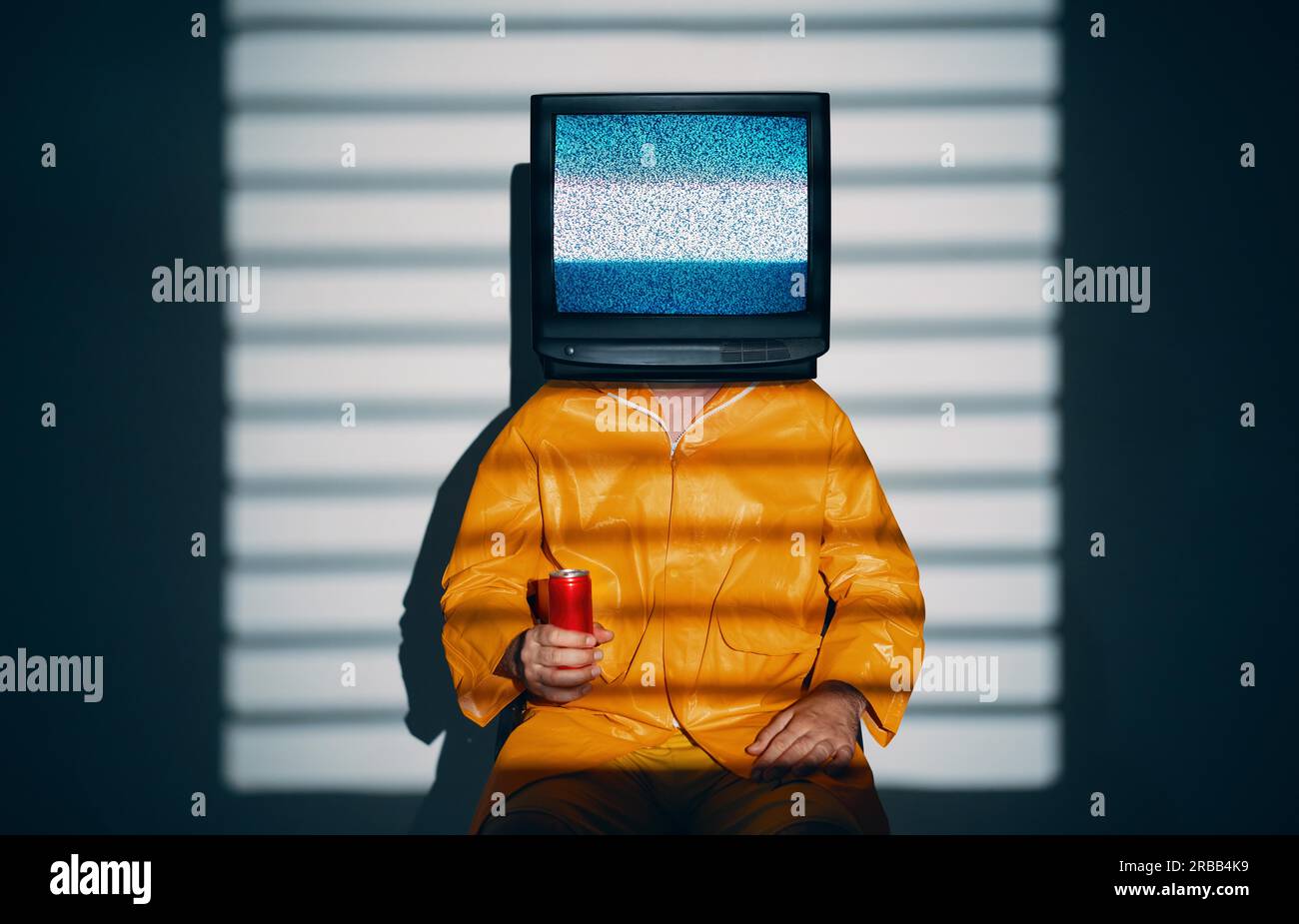 Arte surreale di un uomo dipendente dalla TV con la televisione invece che la testa. Concetto zombie media con uomo in impermeabile giallo brillante che regge una soda dolce in rosso Foto Stock