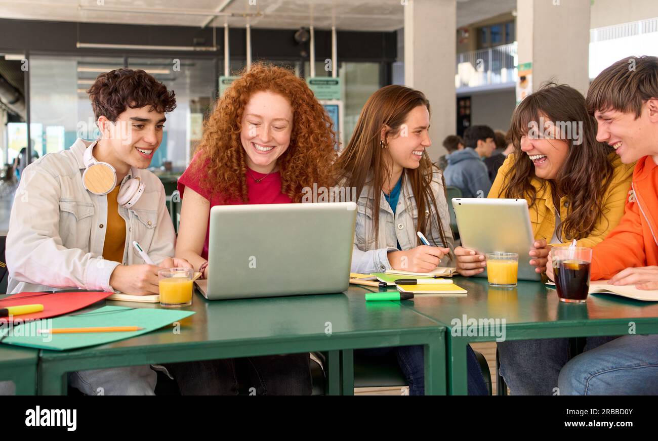 Gruppo sorridente giovani studenti del college caucasico che si preparano per le lezioni riuniti nella caffetteria del campus. Foto Stock