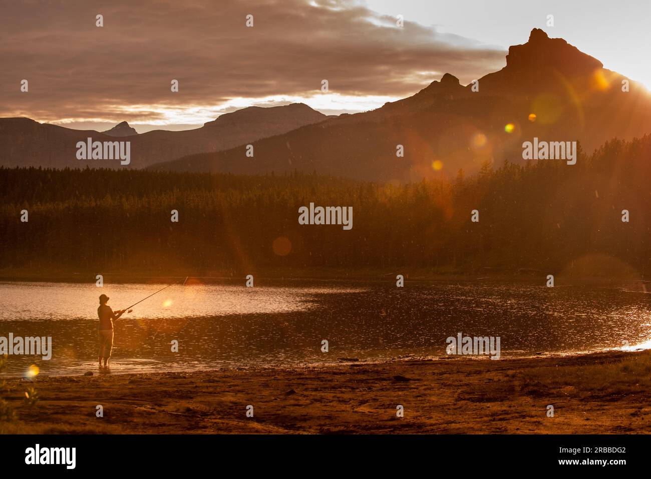 Pesca al tramonto - giovane donna che pesca al lago Margaret nell'area Waiparous dell'Alberta Canada Foto Stock