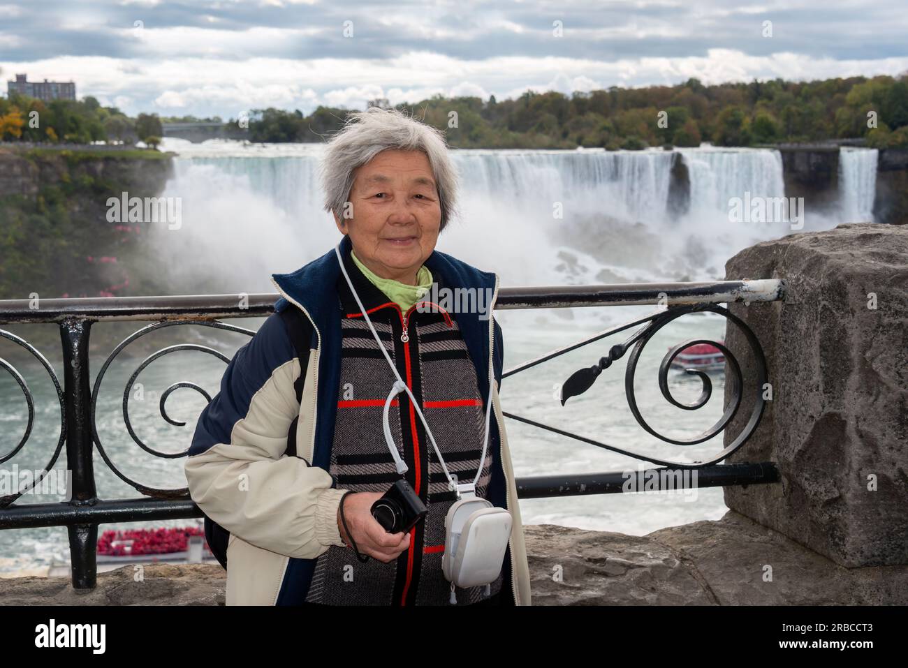 Turisti cinesi in posa per le foto alle cascate del Niagara, Ontario. Canada. Foto Stock