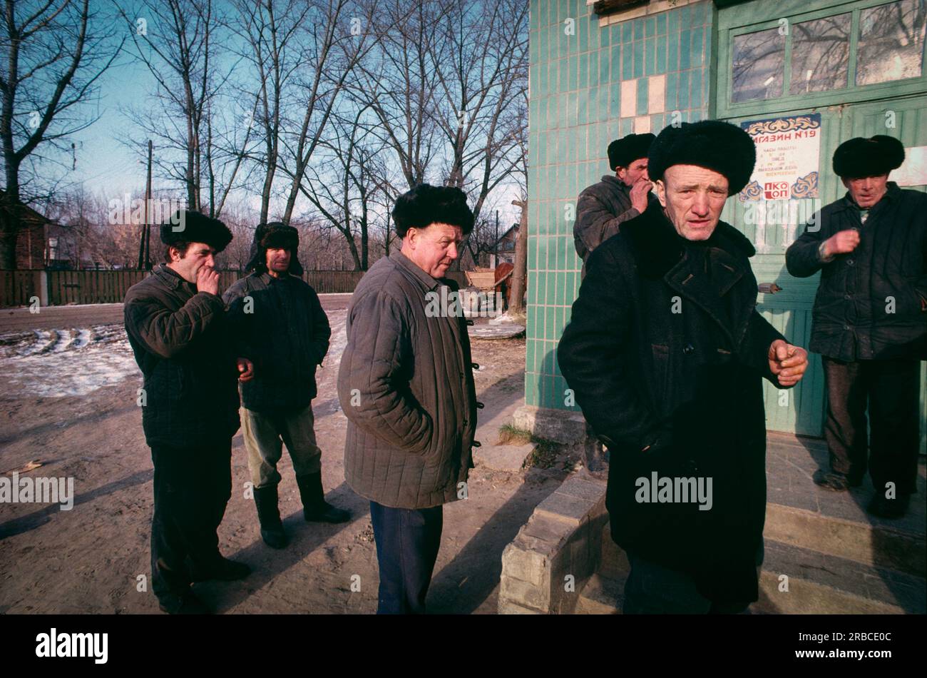 Krasnaya Gora, Repubblica socialista sovietica bielorussa (Bielorussia) 1990. Uomini che aspettano durante una mattina presto d'inverno all'esterno dell'unico negozio di alimentari statale locale. Foto Stock