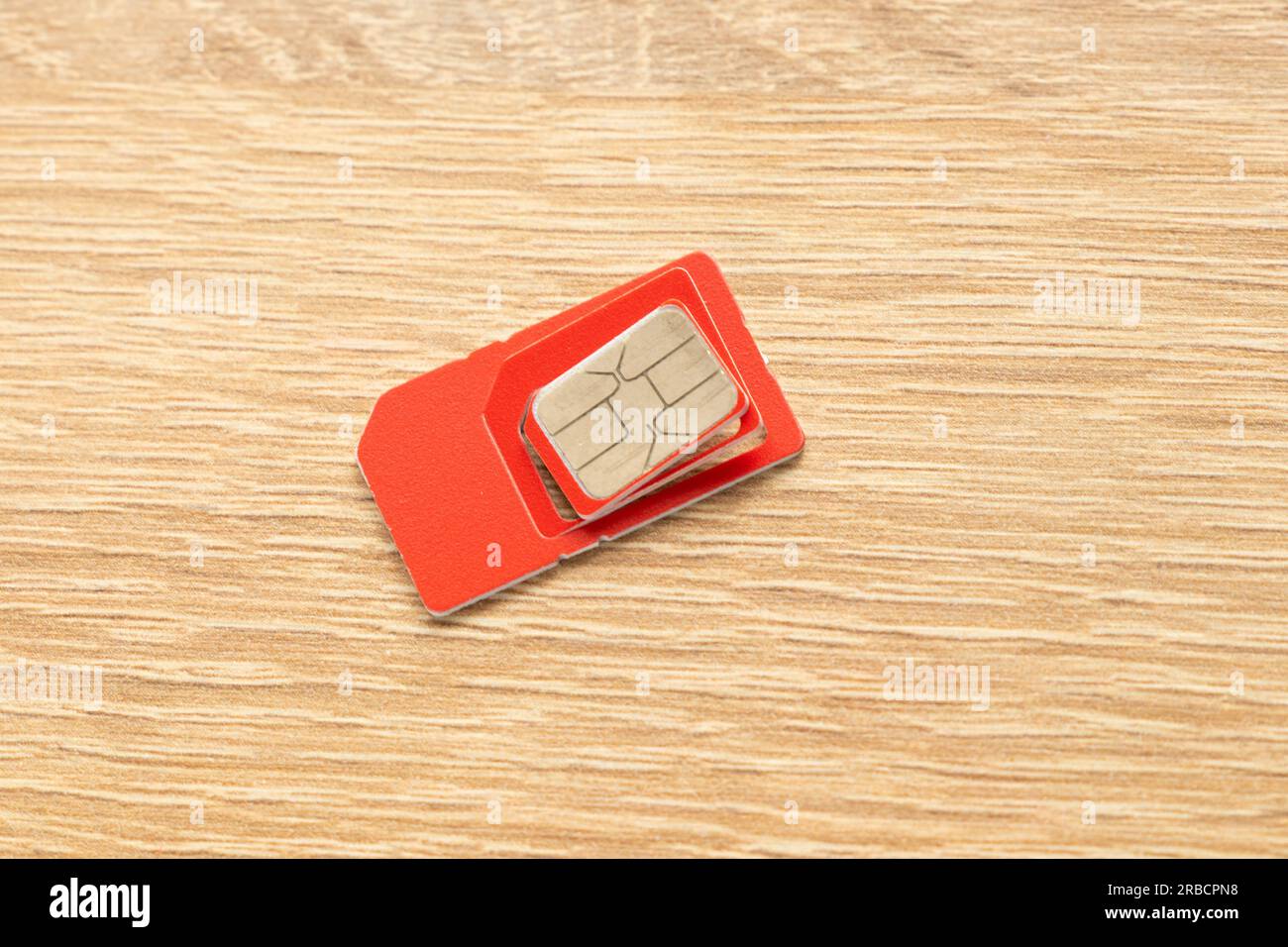 scheda sim di colore rosso su uno sfondo isolato primo piano Foto Stock