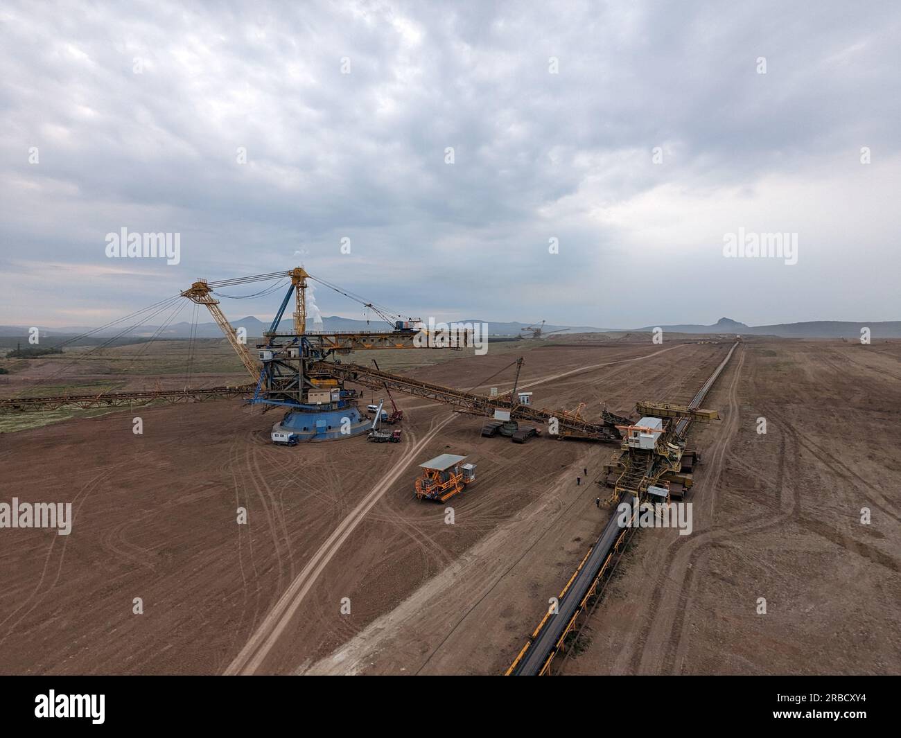 Enormi operazioni di scavo di escavatori gommati a benna nella miniera di carbone nella maggior parte delle regioni della repubblica Ceca, Europa, macchinari pesanti in un paesaggio rivisitato Foto Stock