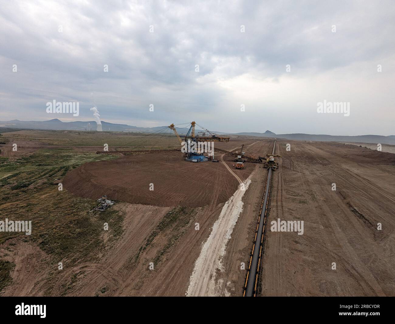 Enormi operazioni di scavo di escavatori gommati a benna nella miniera di carbone nella maggior parte delle regioni della repubblica Ceca, Europa, macchinari pesanti in un paesaggio rivisitato Foto Stock