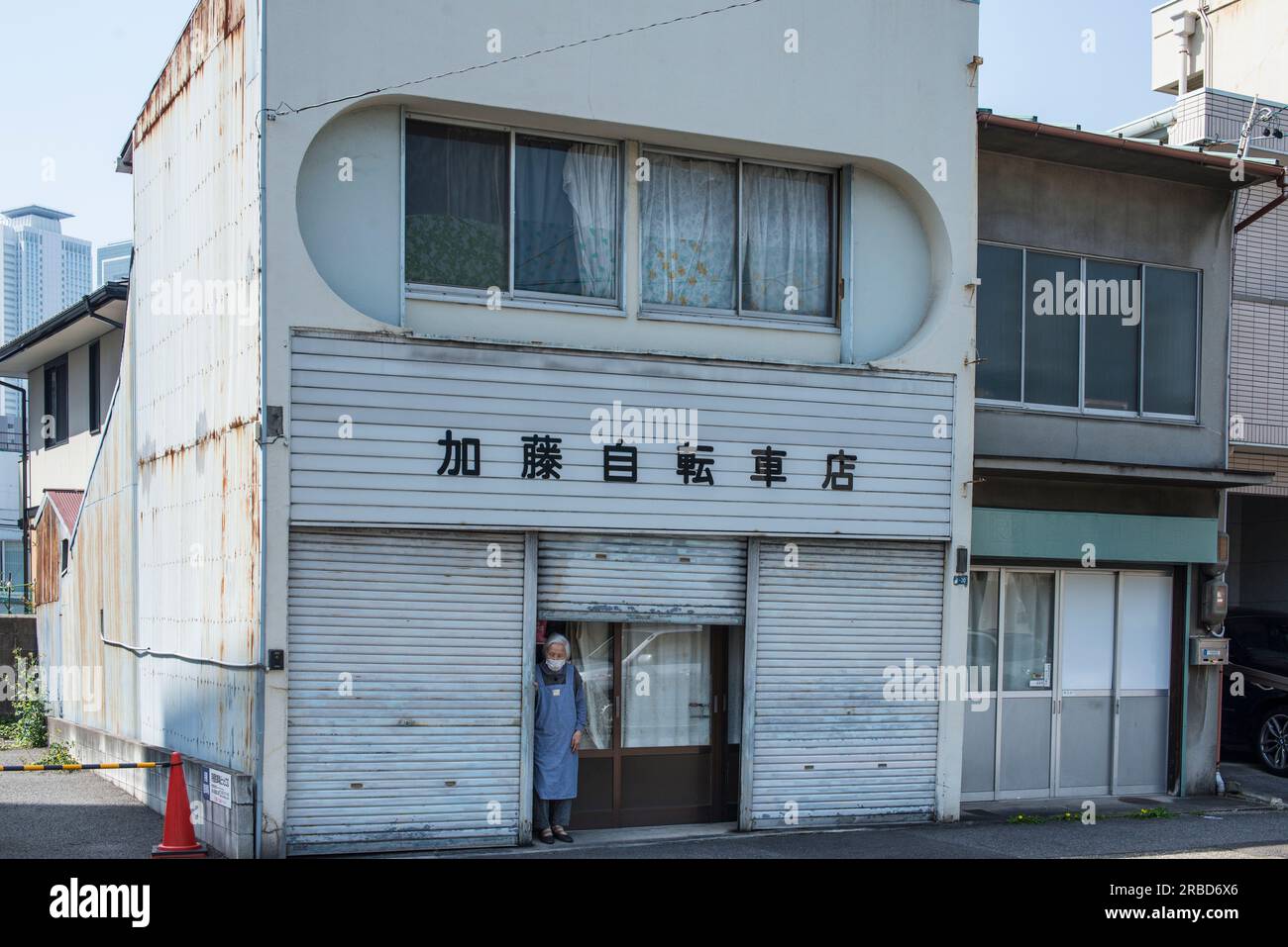Anziana donna giapponese in piedi di fronte a casa sua, Nagoya Foto Stock