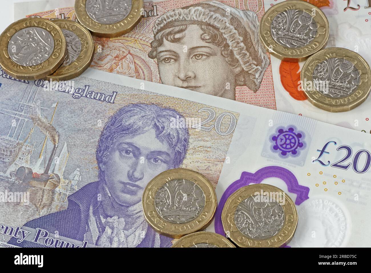 Ho usato monete inglesi da £1 (una sterlina) in primo piano. Su una nota di £ 20 e £ 10 come sfondo. Foto Stock