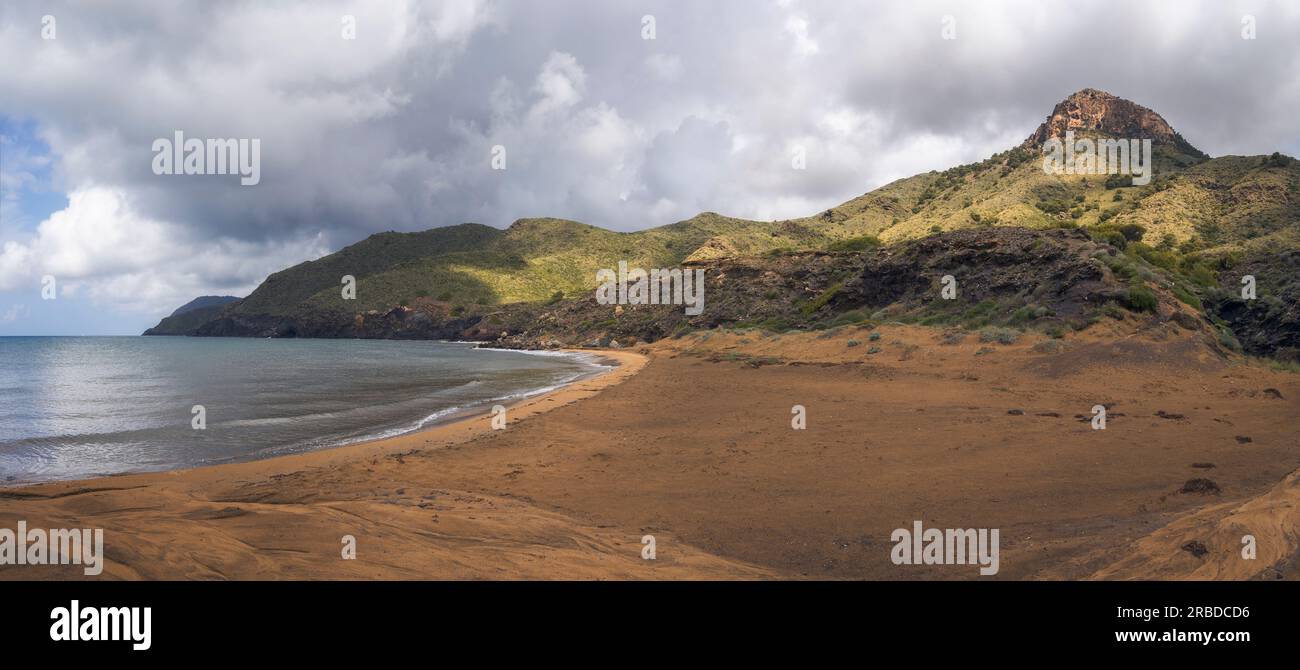 Spiaggia tranquilla, sabbia dorata, onde dolci e paesaggi costieri mozzafiato al Parco Calblanque Regioanl, Murcia, Spagna Foto Stock