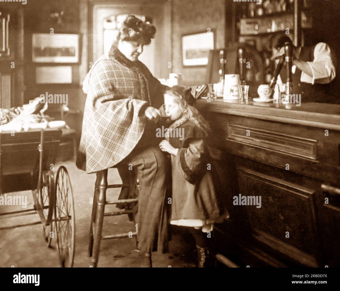 Madre che dà a suo figlio birra in un pub, periodo vittoriano Foto Stock