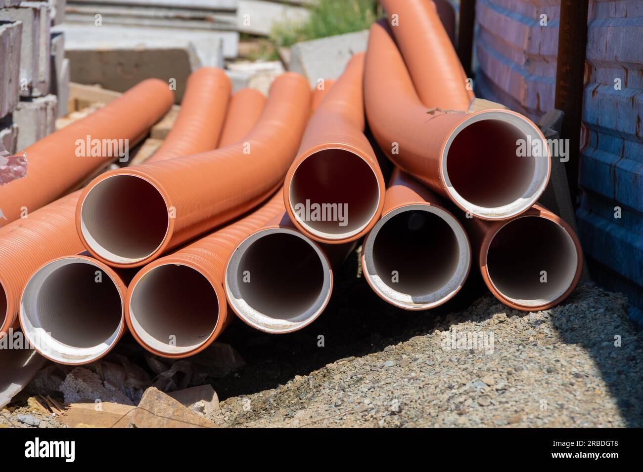 Primo piano del tubo idraulico rosso. Drenaggio, tubi, tubi. Tubi rossi dell'impianto di alimentazione dell'acqua e di riscaldamento. Installazione di un sistema di alimentazione idrica in un rotolo Foto Stock