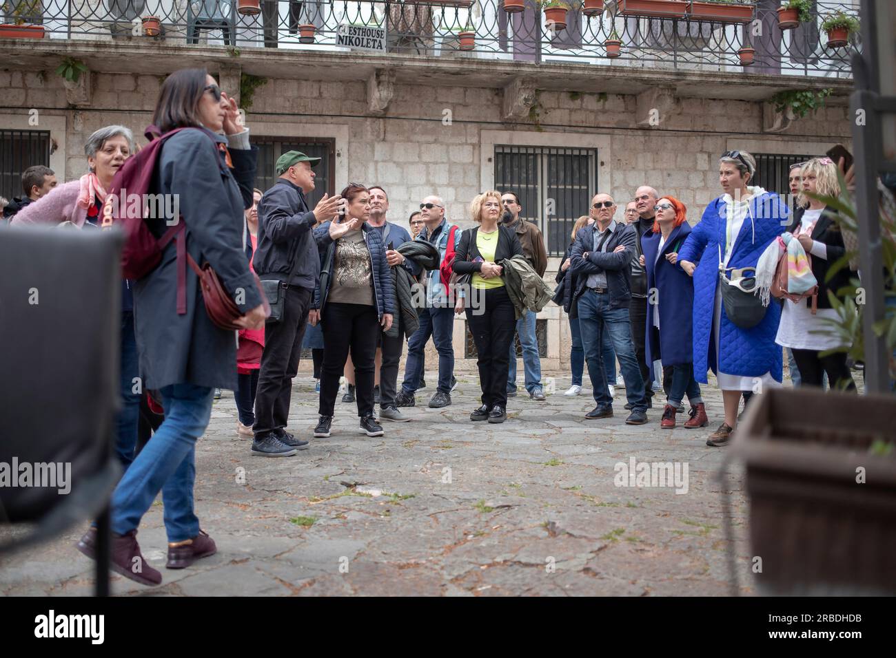 Cattaro, Montenegro, 13 aprile 2023: Un grande gruppo di turisti si è riunito intorno alla guida presso la Piazza del Cinema nella città vecchia Foto Stock