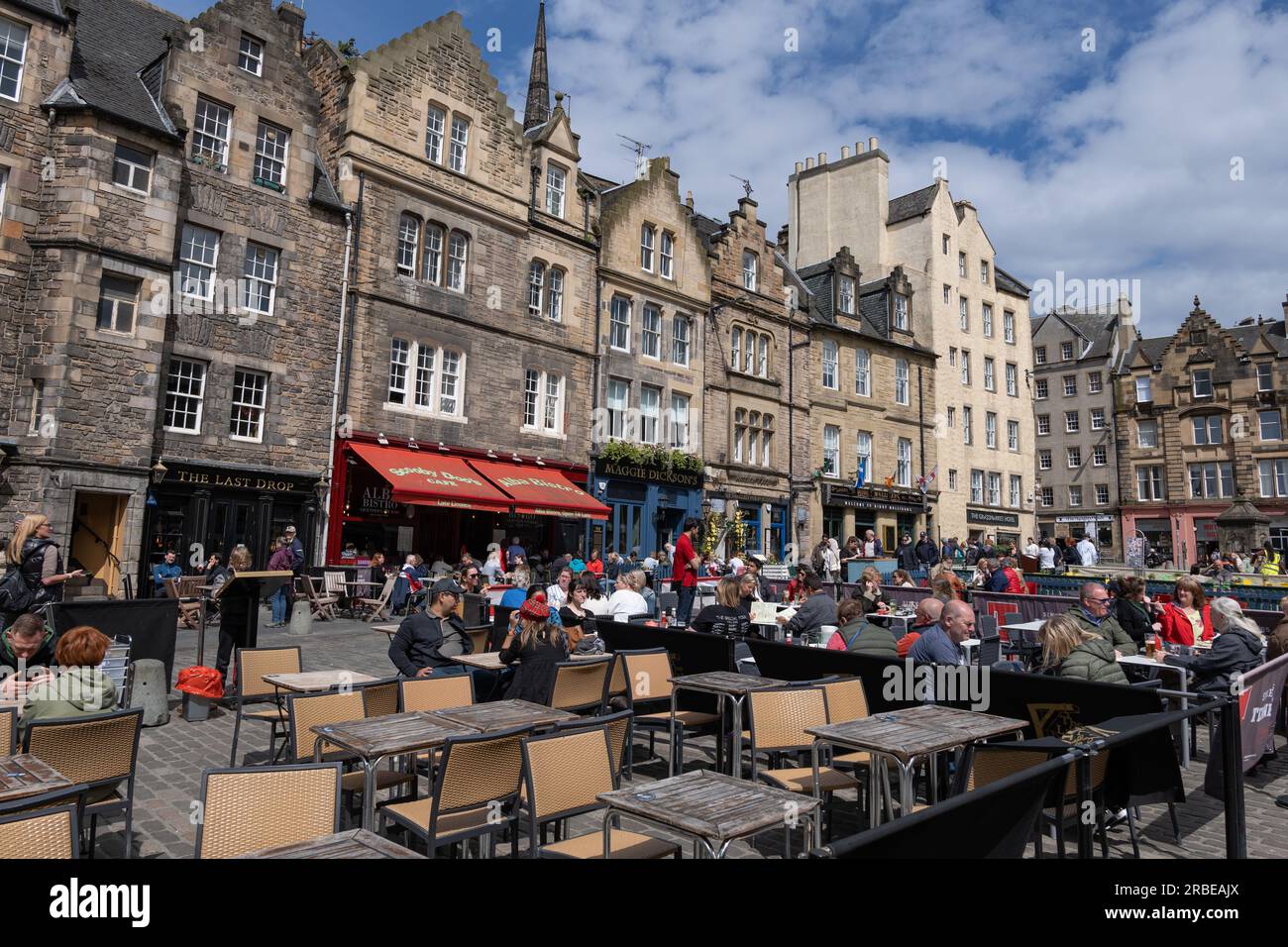 Città di Edimburgo, Scozia, Regno Unito, gente ai tavoli dei ristoranti nella famosa area di Grassmarket, vivace piazza storica del mercato fiancheggiata da bar, pub e ristoranti Foto Stock