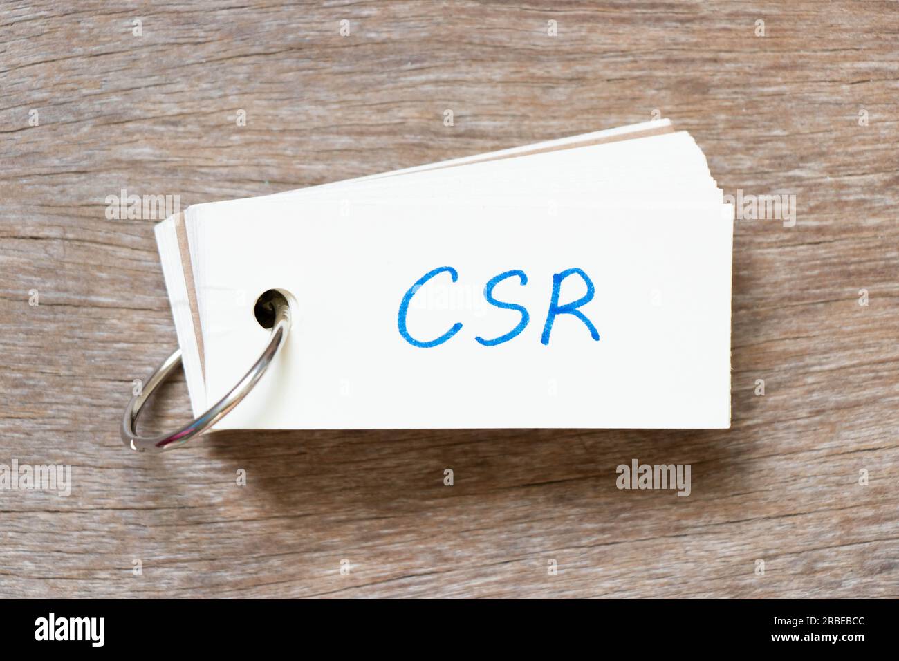 Scheda flash con scrittura a mano in parola CSR (abbreviazione di responsabilità sociale d'impresa) su sfondo di legno Foto Stock