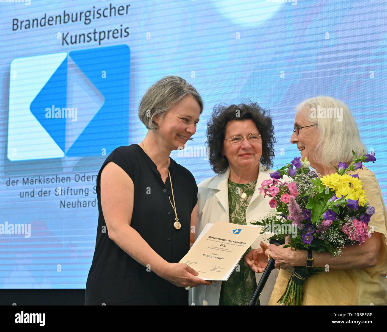 09 luglio 2023, Brandeburgo, Neuhardenberg: Christa Panzner (r), artista, riceve quest'anno il Brandenburg Art Award nella categoria pittura da Angelika Weißbach (l), curatrice, e Heike Kramer, rappresentante generale dello Stiftung Schloss Neuhardenberg. Lo stesso giorno, il 20° Premio d'arte del Brandeburgo è stato assegnato dalla Fondazione Schloss Neuhardenberg e dal giornale Märkische Oderzeitung. Inoltre, ci sono due premi speciali. Nel 2023, il premio sarà sostenuto per la prima volta dalla Cancelleria di Stato del Brandeburgo in qualità di partner. La mostra di accompagnamento al Castello di Neuhardenbe Foto Stock