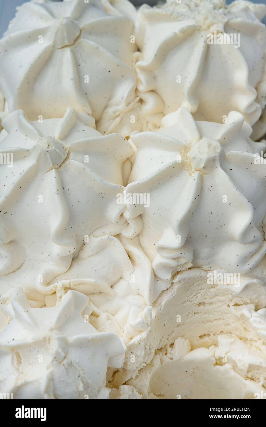 Gelato alla vaniglia conservato in una vetrina, un classico e versatile dessert surgelato con una consistenza morbida e cremosa e un profilo dal sapore delicato Foto Stock