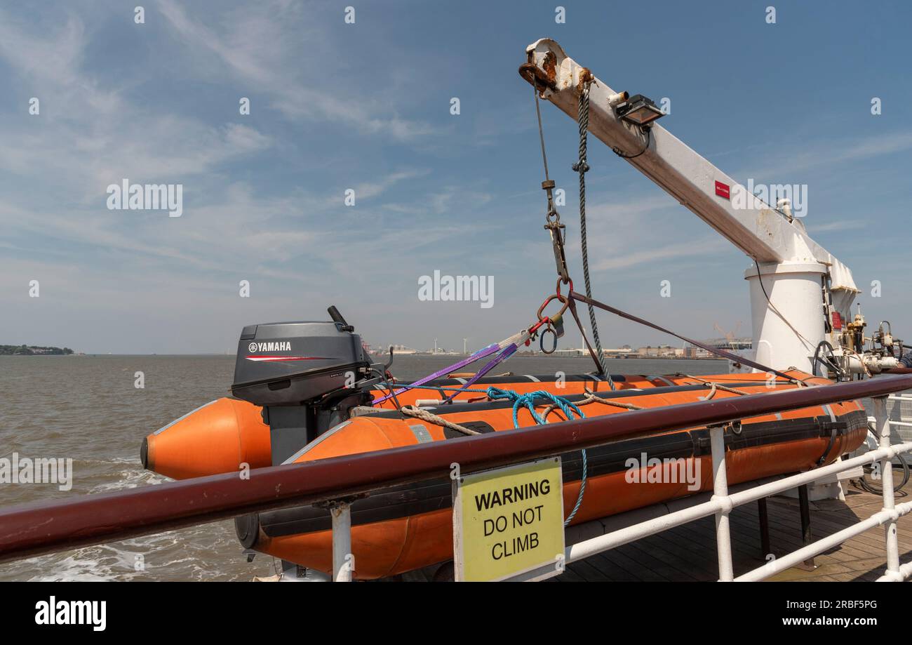 Liverpool, Inghilterra, Regno Unito. 8 giugno 2023. Liftraft con motore fuoribordo stivato con una gru a poppa di un traghetto sul fiume Mersey. Foto Stock
