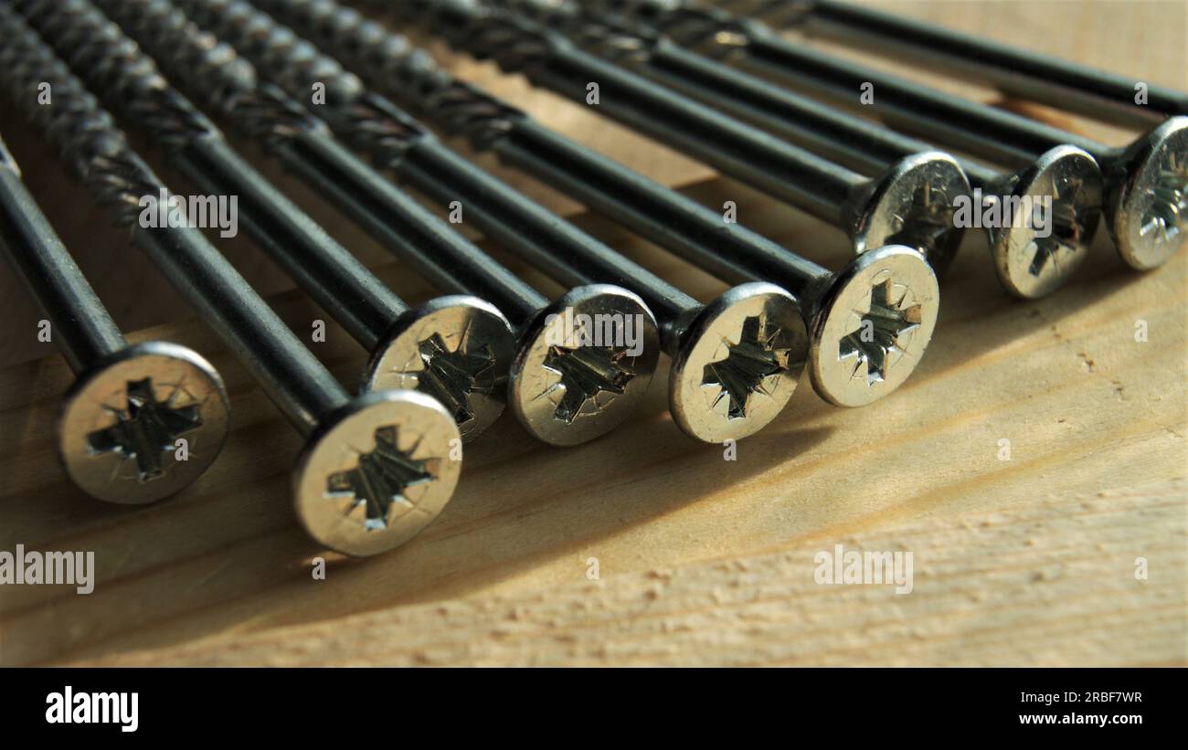 Primo piano delle viti lunghe in argento. Viti per la costruzione di strutture in legno. Foto Stock