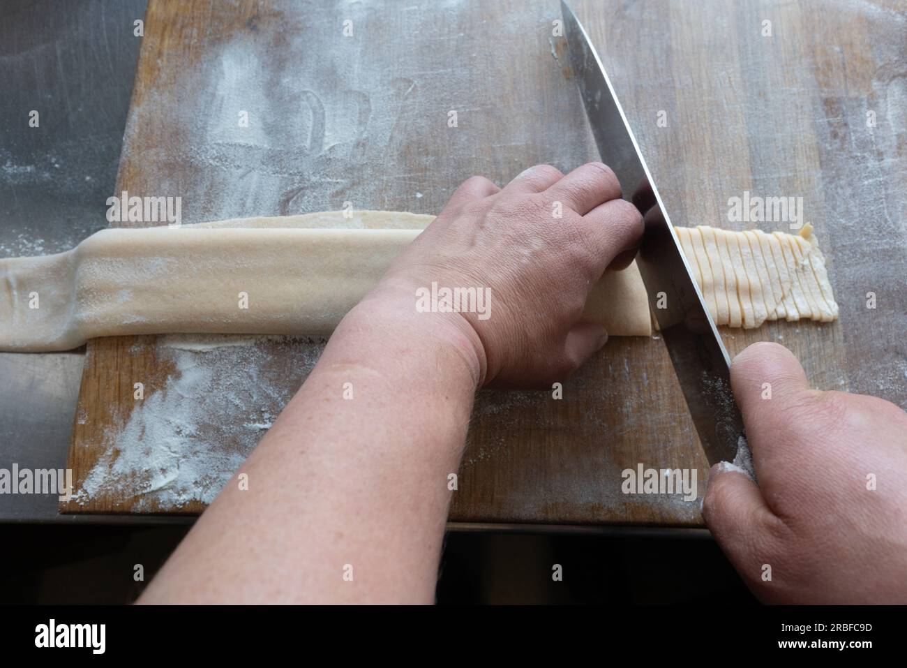 Pasta fresca tagliata a mano dallo chef maschio. Foto Stock