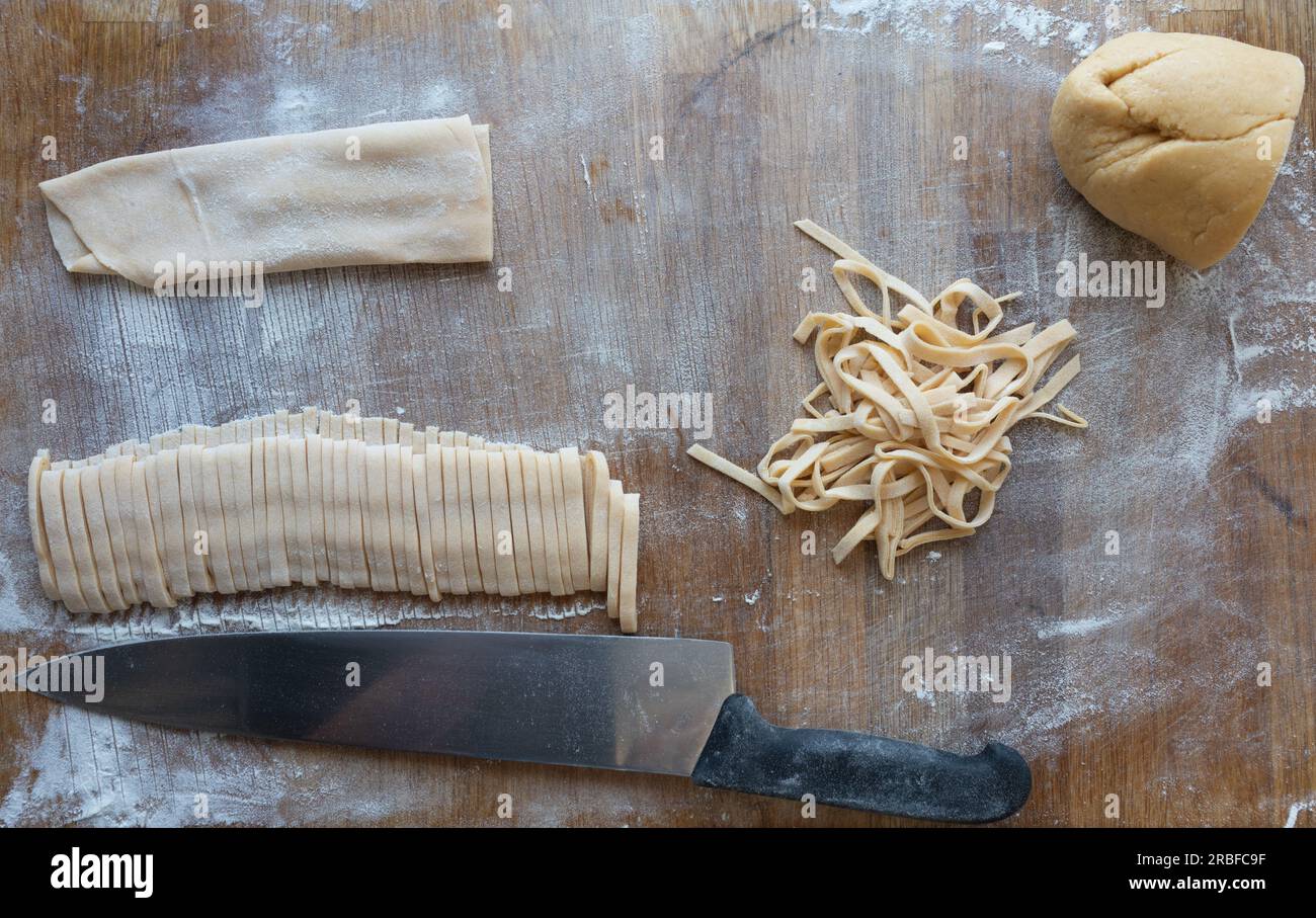 Processo di preparazione della pasta fatta in casa tempo di taglio su un tavolo di legno. Foto Stock