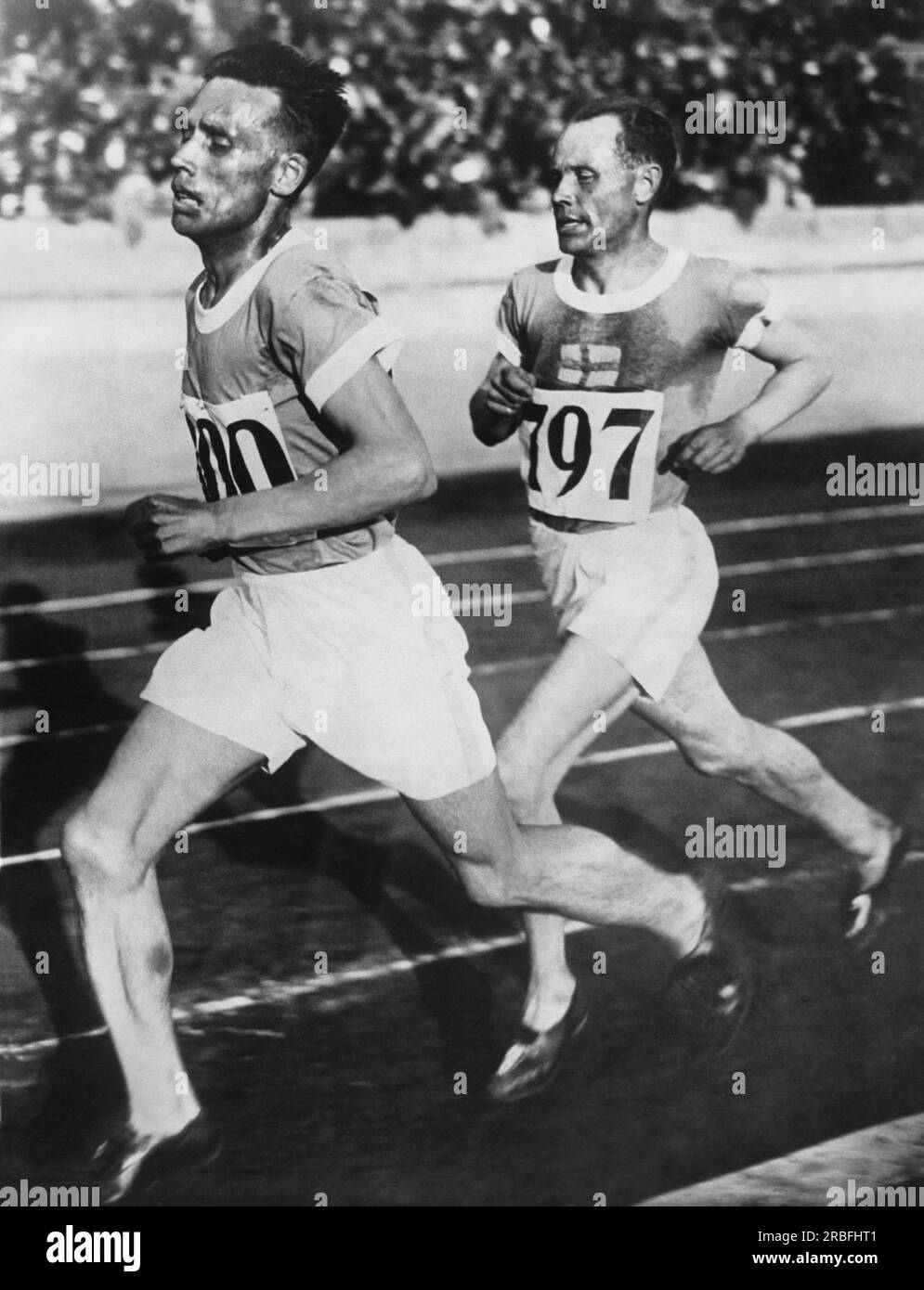 Amsterdam, Paesi Bassi: Il corridore finlandese Ville Ritola nel 1928 guida il suo connazionale Paavo Nurmi nella gara dei 10.000 metri alle Olimpiadi estive del 1928. Nurmi ha preso l'oro mentre Ritola ha vinto la medaglia d'argento. Foto Stock