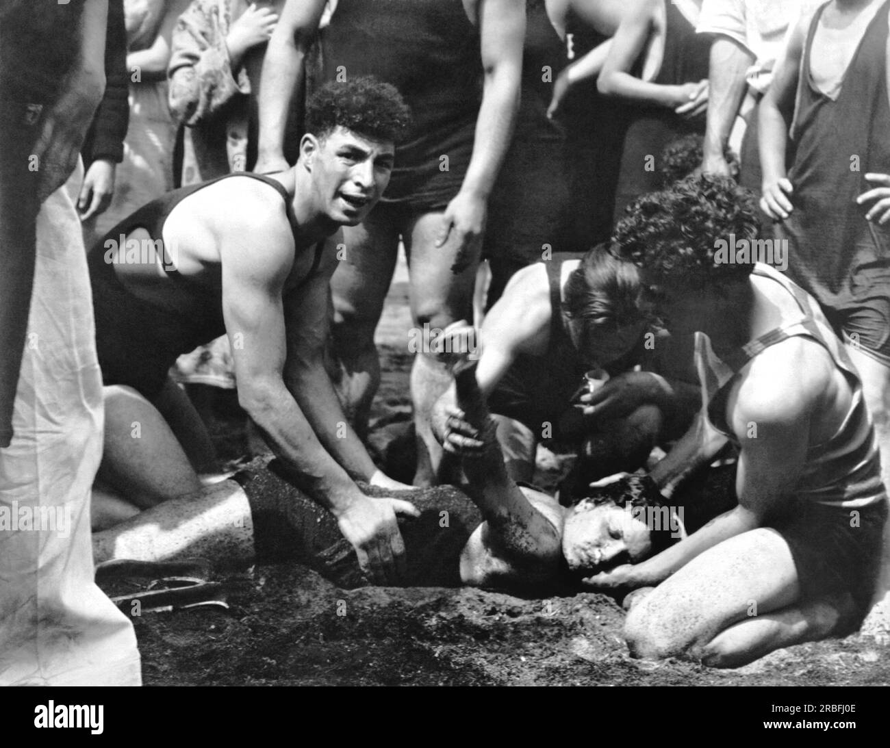 Farmer's Dock, New York: c. 1928 Un bagnino che rianimava una giovane nuotatrice che aveva salvato dopo essere scesa per la terza volta durante un caldo Memorial Day a Long Island. Foto Stock