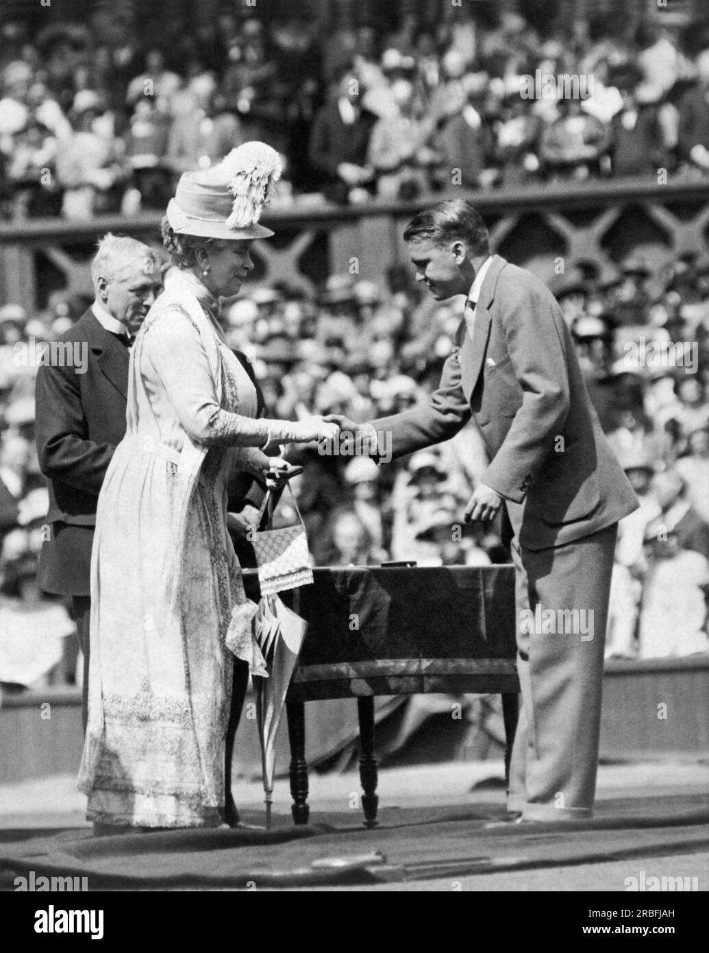 Londra, Inghilterra: 1926 King George V e Queen Mary al Jubilee Lawn Tennis Championships a Wimbledon. Il re ha consegnato medaglie di commercio agli ex campioni e la regina Mary sta salutando Vincent Richards degli Stati Uniti, vincitore del doppio nel 1924. Foto Stock