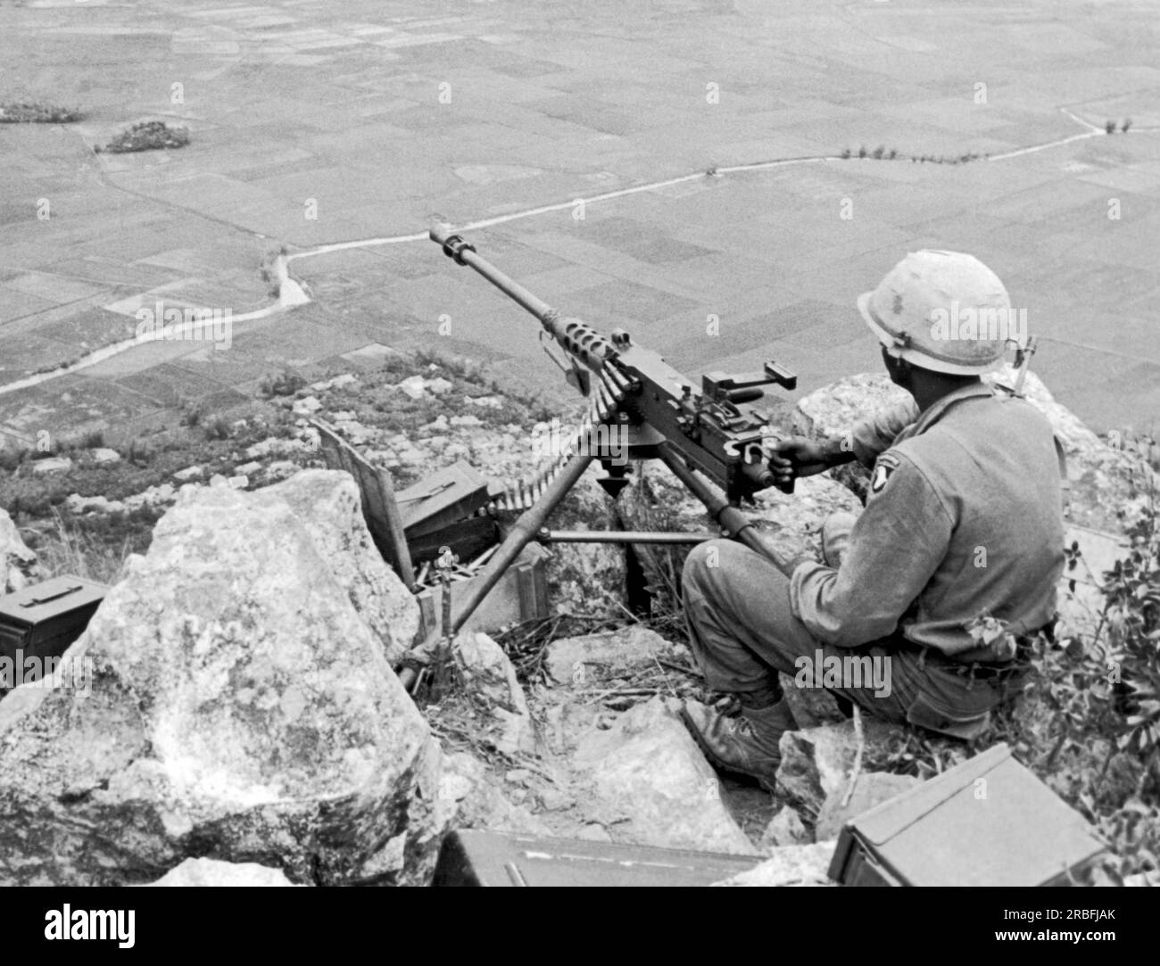 Tuy Hoa, Vietnam: 24 agosto 1966 Un mitragliatore della 101st Airborne Division arroccato sulla cima di una montagna ha una vista dominante della valle sottostante. Foto Stock