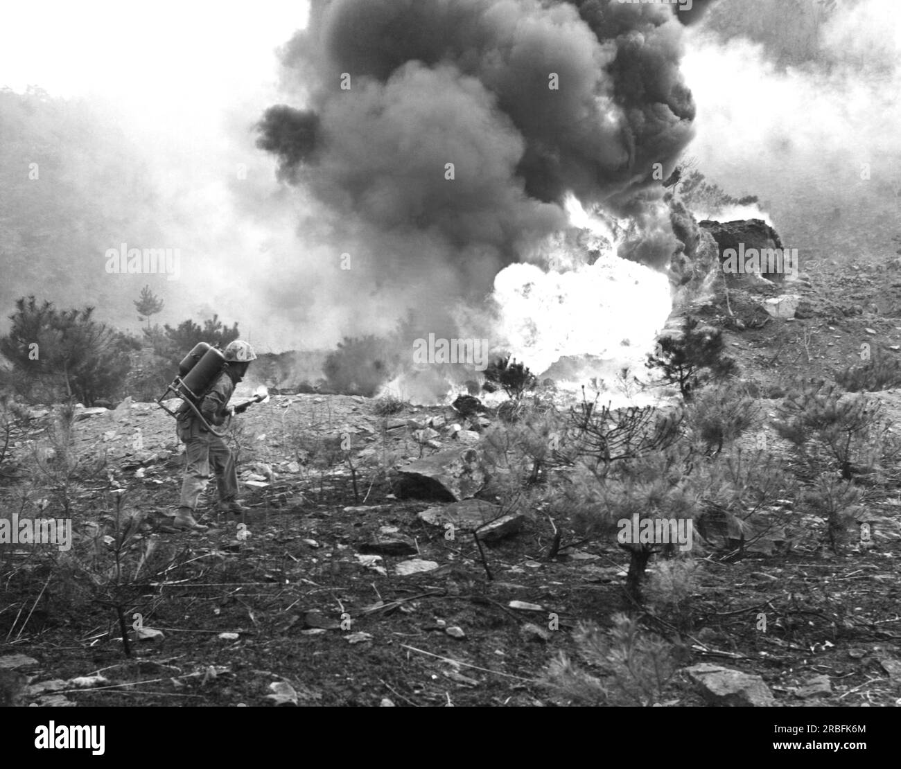 Corea: c. 1950 Un Marine della First Marine Division attacca una cella nemica con un lanciafiamme. Foto Stock
