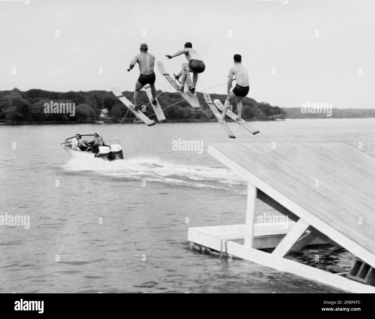 Stati Uniti: c. 1956 tre membri del min-Aqua Bats Waterski Club prendono il salto simultaneamente come parte dello spettacolo di sci d'acqua. Foto Stock