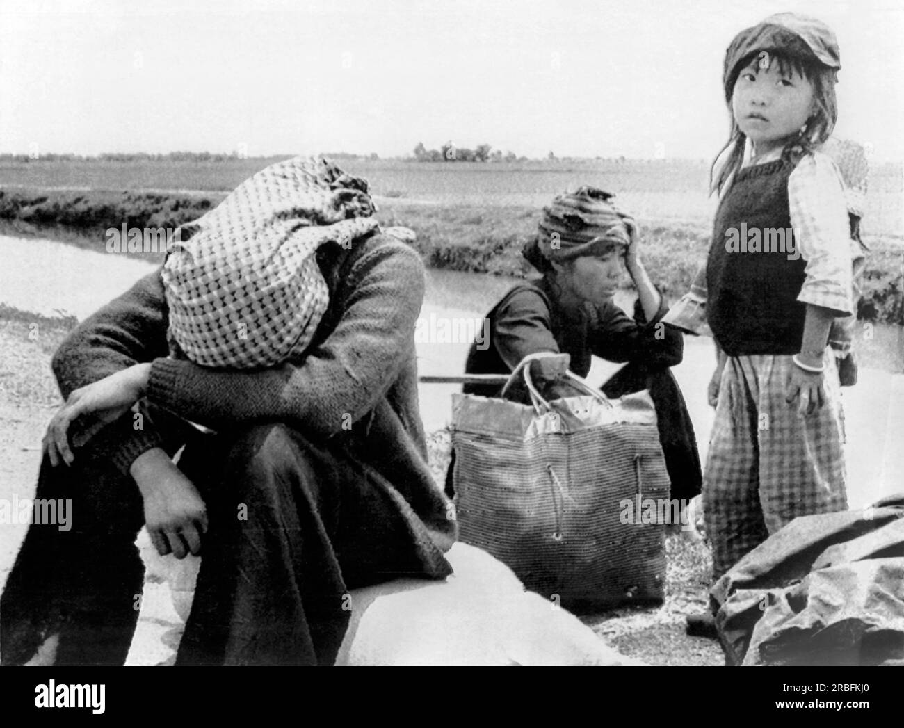 Vietnam: Il 29 marzo 1975 Una donna stanca e i suoi figli sull'autostrada 1 sono tre delle tante migliaia che sono state bloccate per prendere le strade e la lunga passeggiata verso la sicurezza. Vengono dalle Highlands centrali e stanno cercando di farsi strada a Nha Trang. Foto Stock