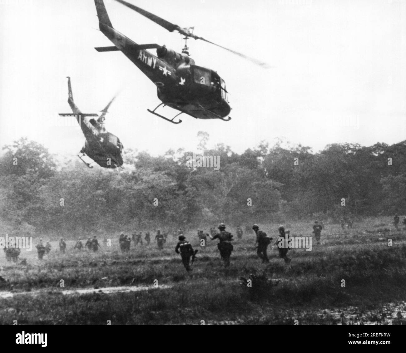 Ben Hoa, Vietnam: circa 1967 Stati Uniti I soldati aviotrasportati dell'esercito si spostano attraverso il fuoco dei cecchini Viet Cong verso la giungla dopo essere stati sganciati dagli Hueys in un campo di riso. Foto Stock