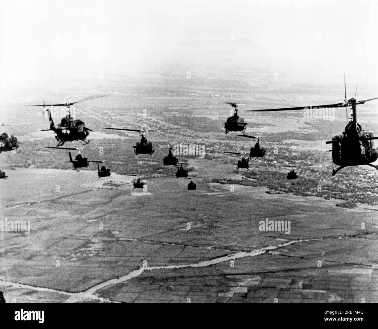 Trang Bang, Vietnam: circa 1967 Hueys riempiono l'aria mentre si dirigono verso il combattimento contro i Viet Cong. Foto Stock