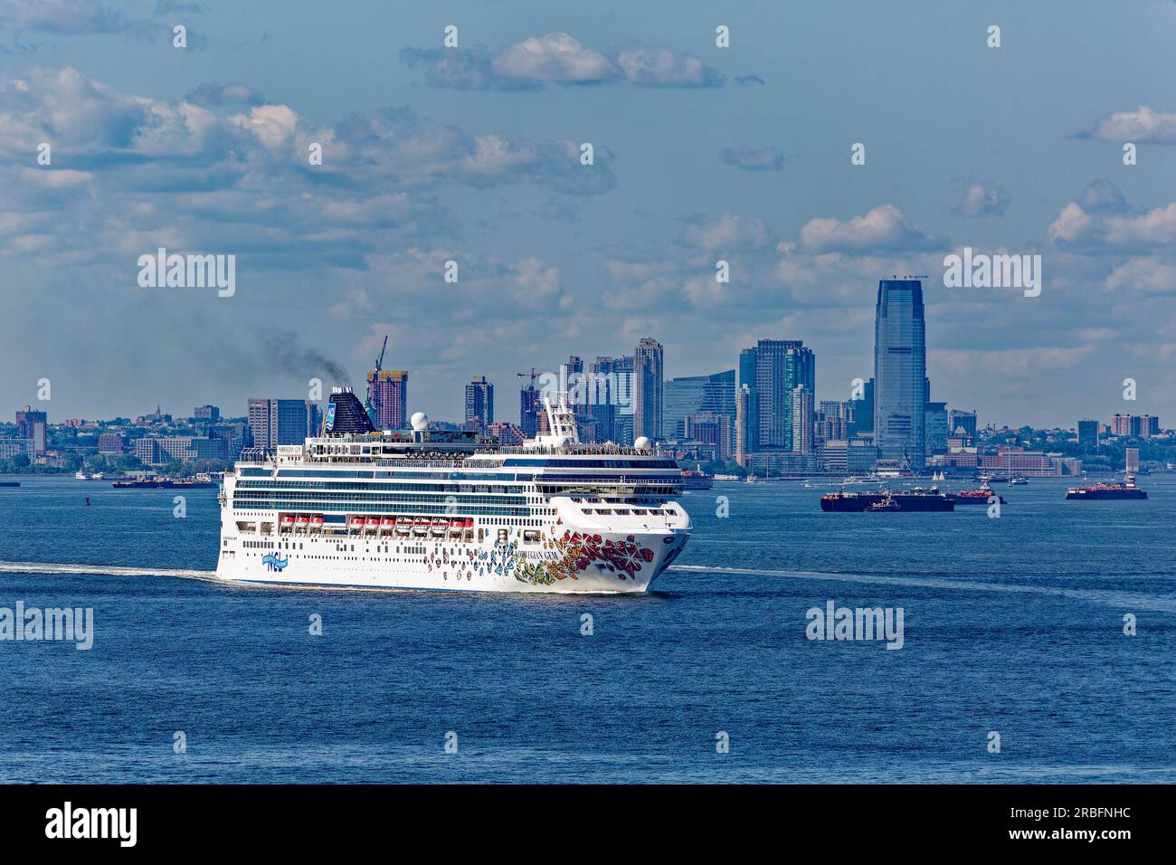 La Norwegian Gem della Norwegian Cruise Line, in partenza dal porto di New York con Jersey City, New Jersey, per uno sfondo, sotto cieli parzialmente nuvolosi. Foto Stock