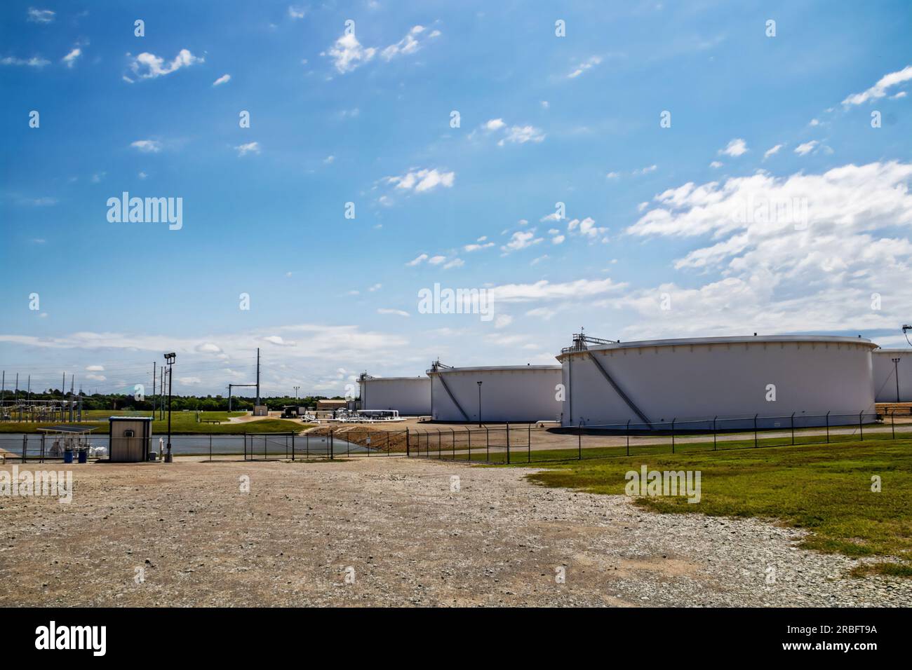 Serbatoi di contenimento petrolchimico presso una fattoria di serbatoi a Cushing Oklahoma USA con laghetto Foto Stock