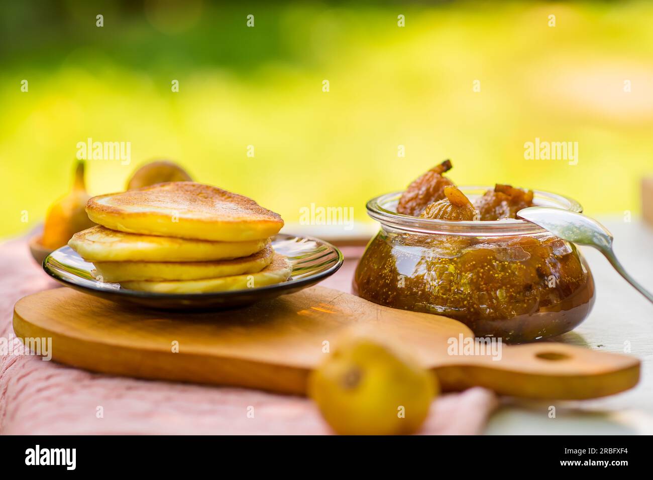 marmellata di fichi e pancake al tavolo, giardino estivo Foto Stock