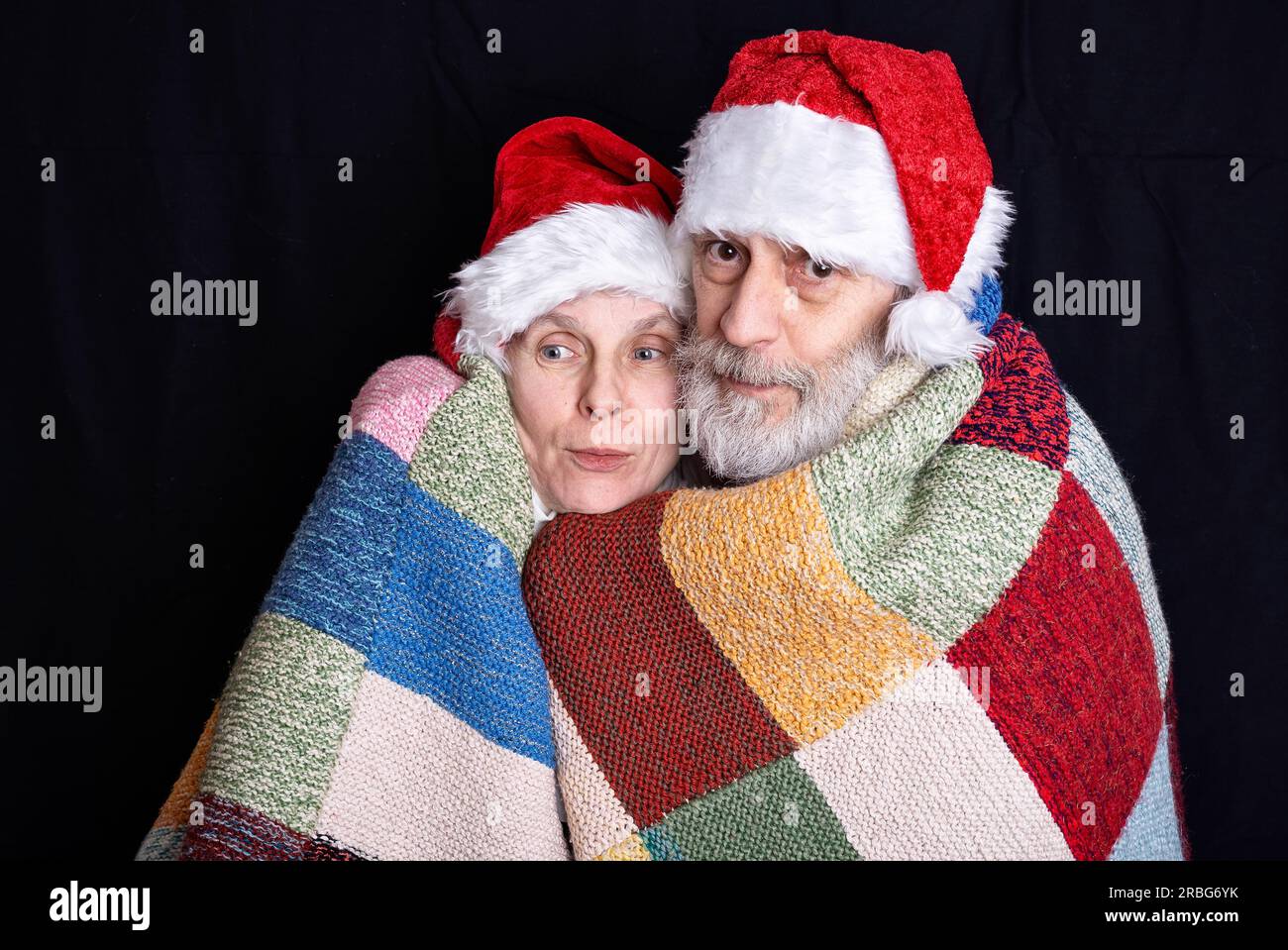 Ritratto di un uomo adulto con barba bianca e una donna mascherata in Babbo Natale per le vacanze di Natale e Capodanno Foto Stock