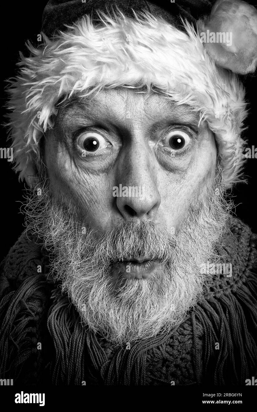 Ritratto in bianco e nero di un uomo adulto con barba bianca mascherata in Babbo Natale per le vacanze di Natale e Capodanno Foto Stock