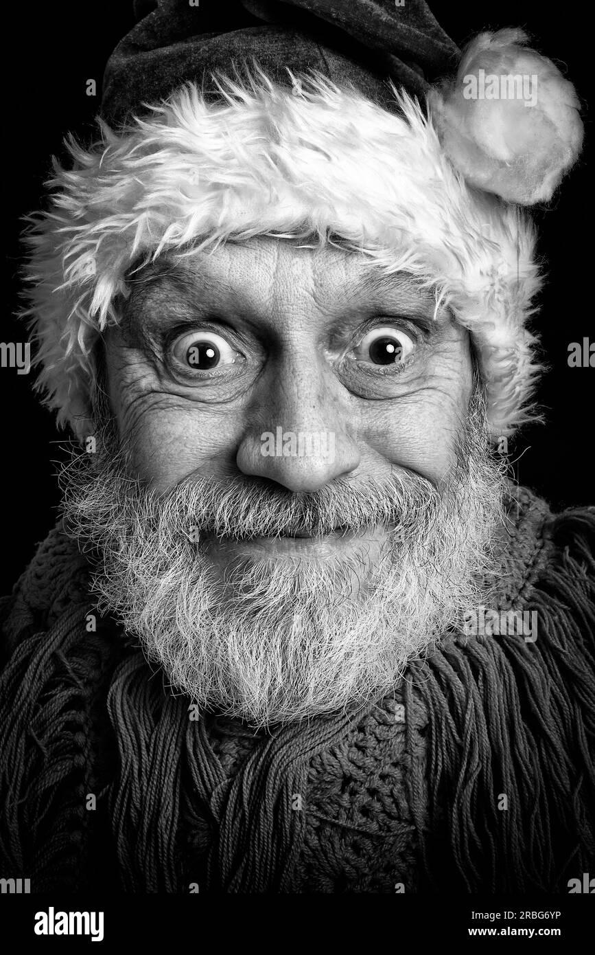 Ritratto in bianco e nero di un uomo adulto con barba bianca mascherata in Babbo Natale per le vacanze di Natale e Capodanno Foto Stock