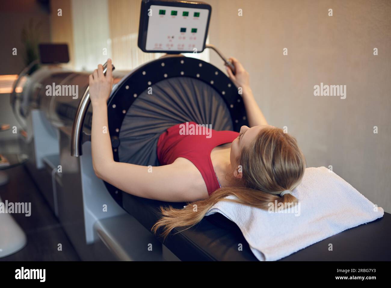 Montare attraente giovane donna facendo terapia a vuoto per la prevenzione e la rigenerazione, sorridente in telecamera Foto Stock