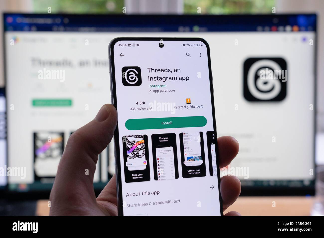 Mano dell'uomo che tiene in mano uno smartphone che visualizza la schermata di download e installazione di Google Play per i thread e il relativo logo, un'app Instagram di Meta. REGNO UNITO Foto Stock