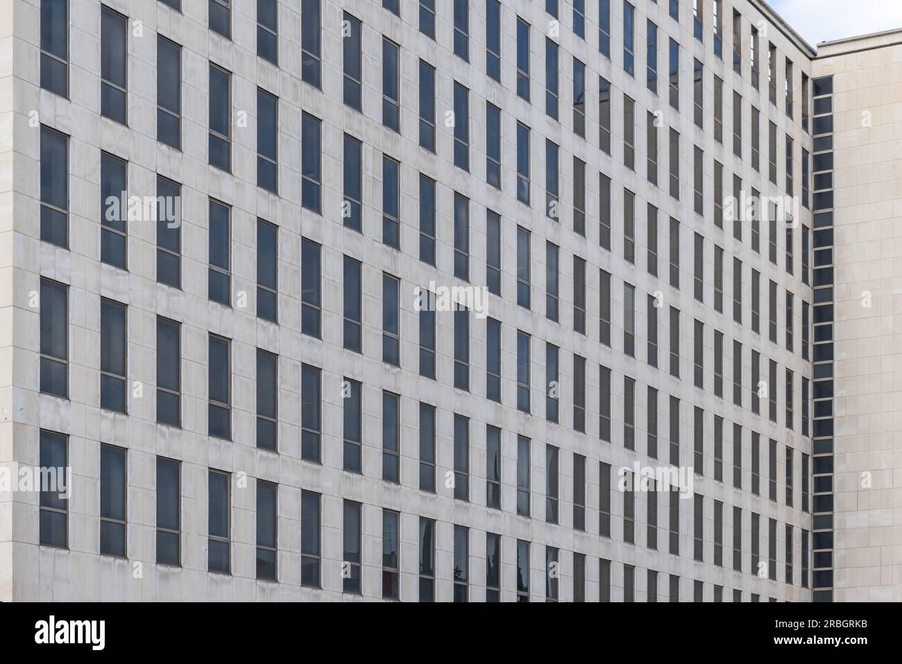 facciata di un edificio di uffici con piastrelle di marmo e molte piccole finestre strette Foto Stock