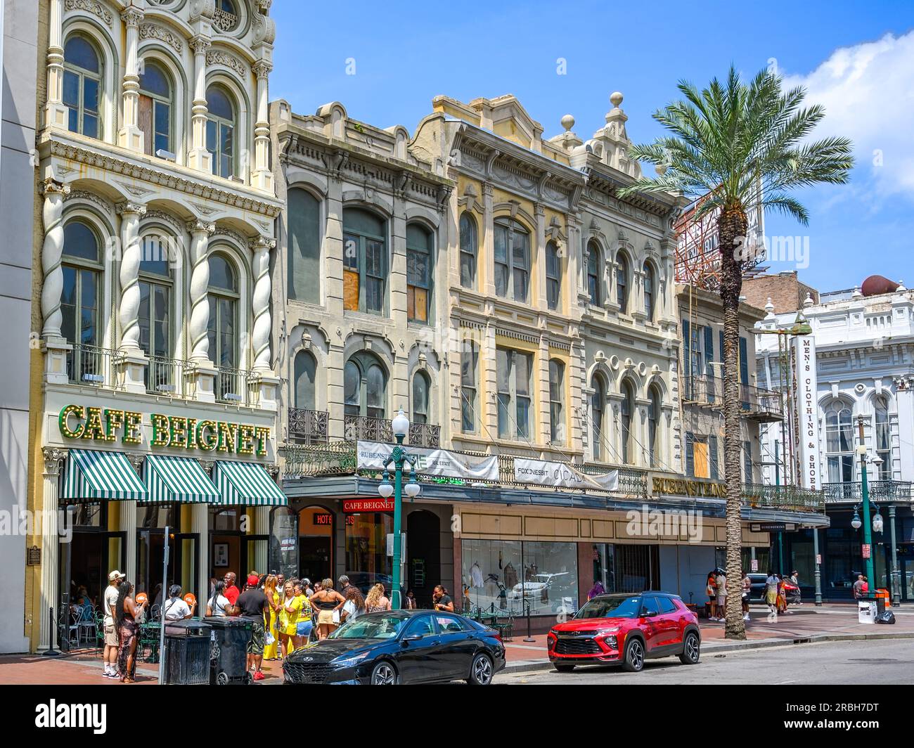 NEW ORLEANS, LOUISIANA, USA - 2 LUGLIO 2023: Paesaggio urbano della sezione di Canal Street che include Cafe Beignet (con folla) e Rubenstein's Clothing Store Foto Stock