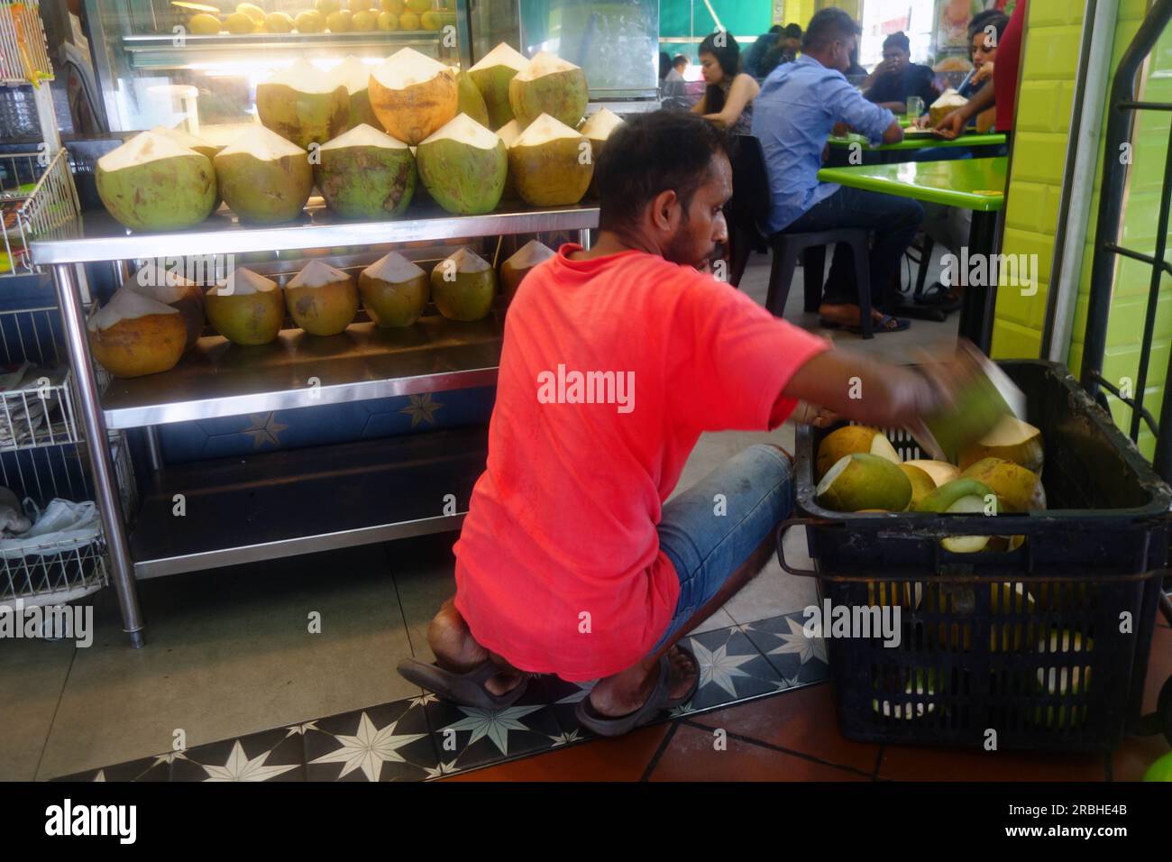 Uomo che consegna noci di cocco al ristorante, Little India, Singapore. No MR o PR Foto Stock