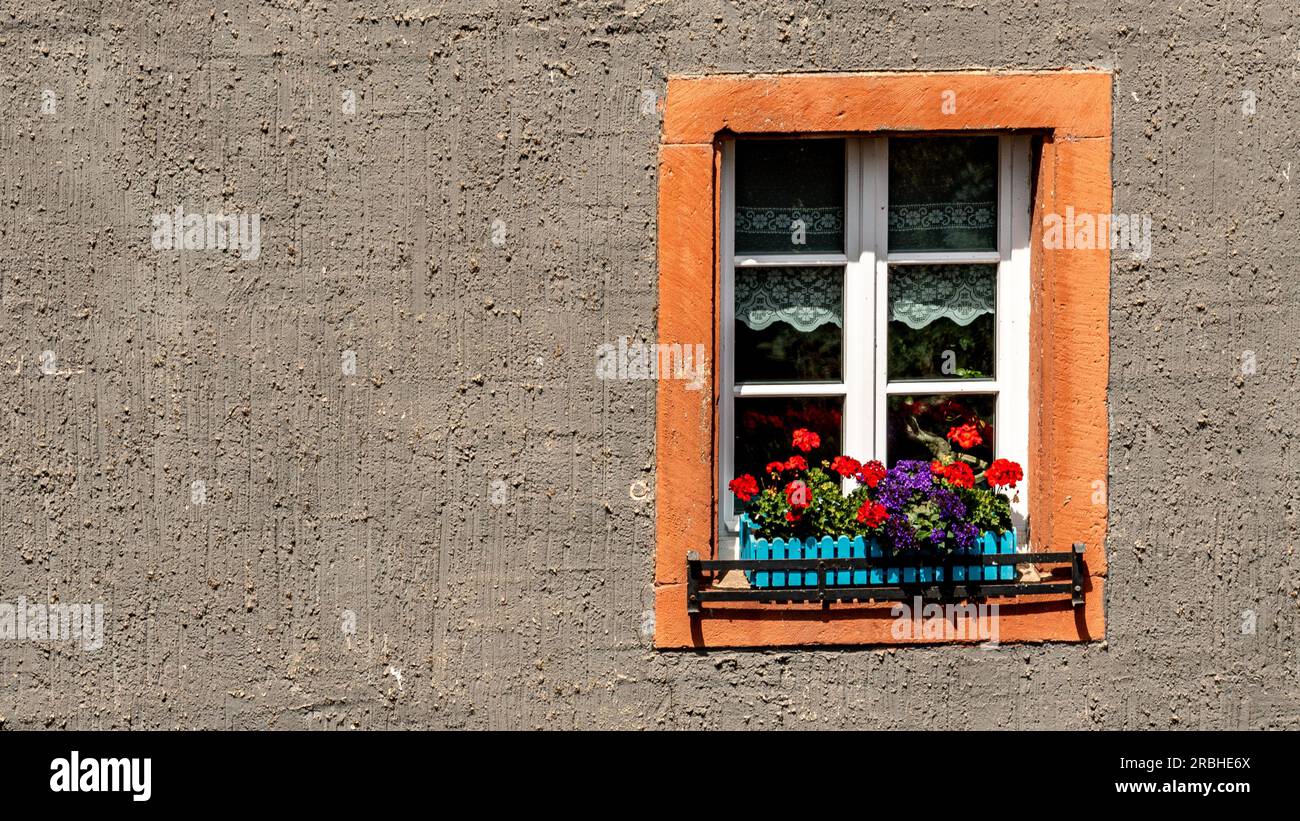 Una finestra colorata su un edificio grigio Foto Stock